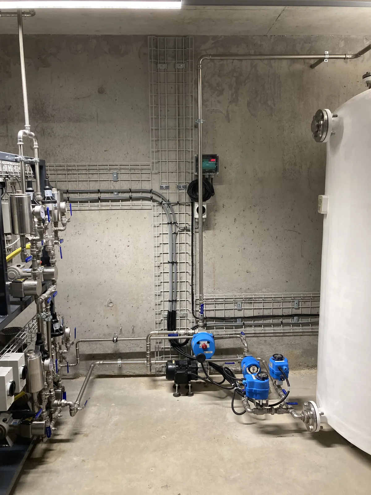 SNCR plant room with dosing lines, pumps and urea mixing tank – biomass plant, Switzerland